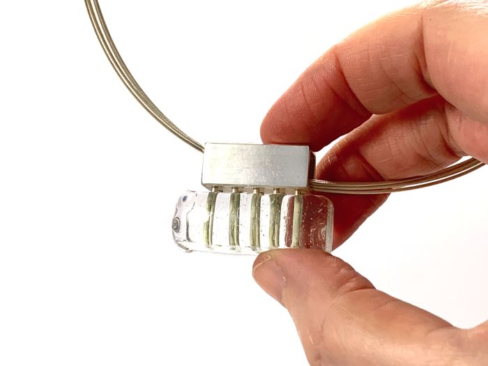 Rechteckiger Anhänger aus klarem Glas,  in der Hand